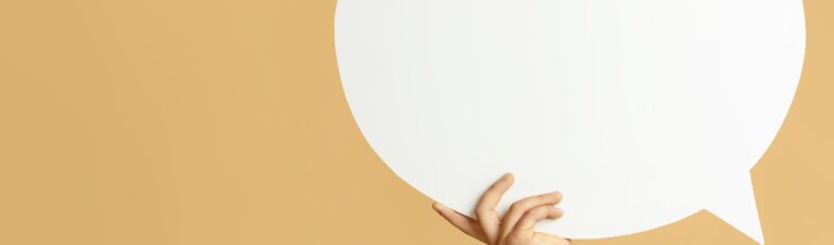 Sprechblase, die von einer Hand gehalten wird.