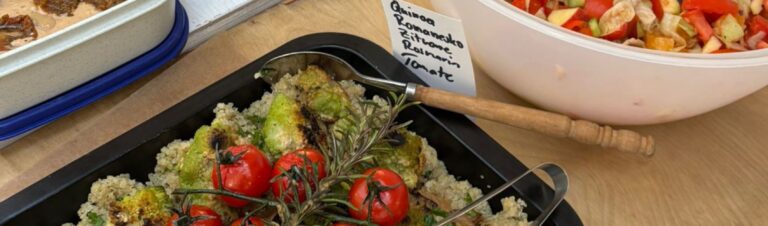 Ofenform gefüllt mit Quinoa, Romanesko, Zitrone, Rosmarin und Tomate. Dahinter sieht man weitere Schüsseln, die auf einem Tisch beim Veganer Brunch in der Kulturküche stehen.