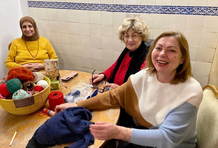 Frauen häkeln an einem Tisch