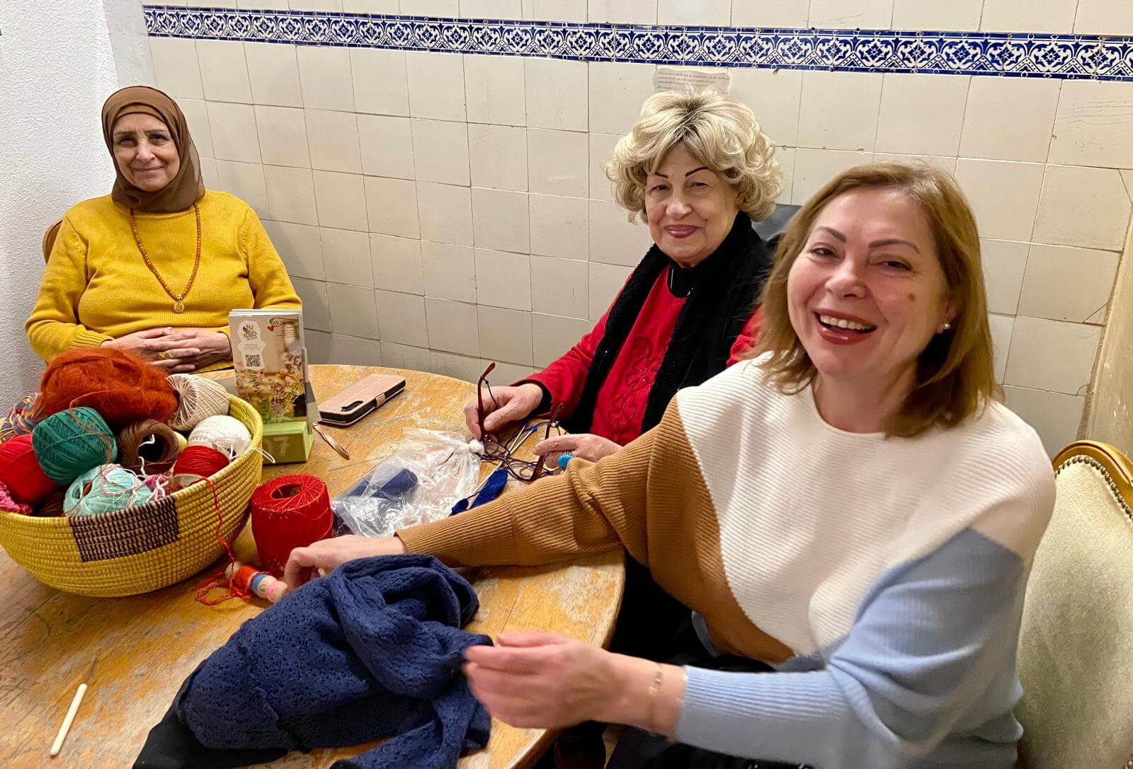 Frauen häkeln an einem Tisch